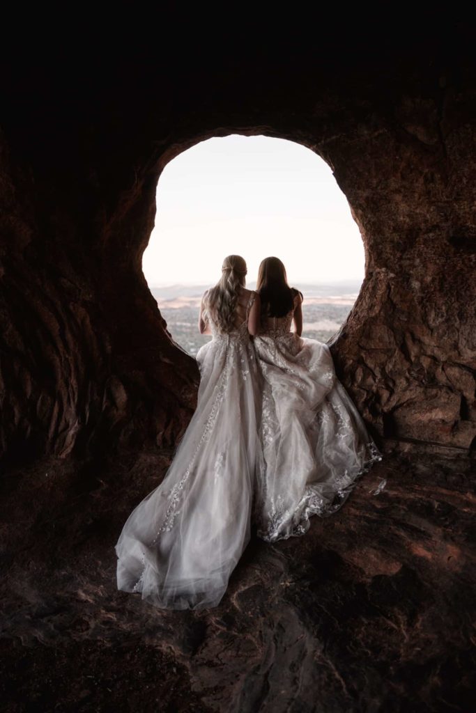 Photo of two beautiful women in white dresses having a meaningful moment