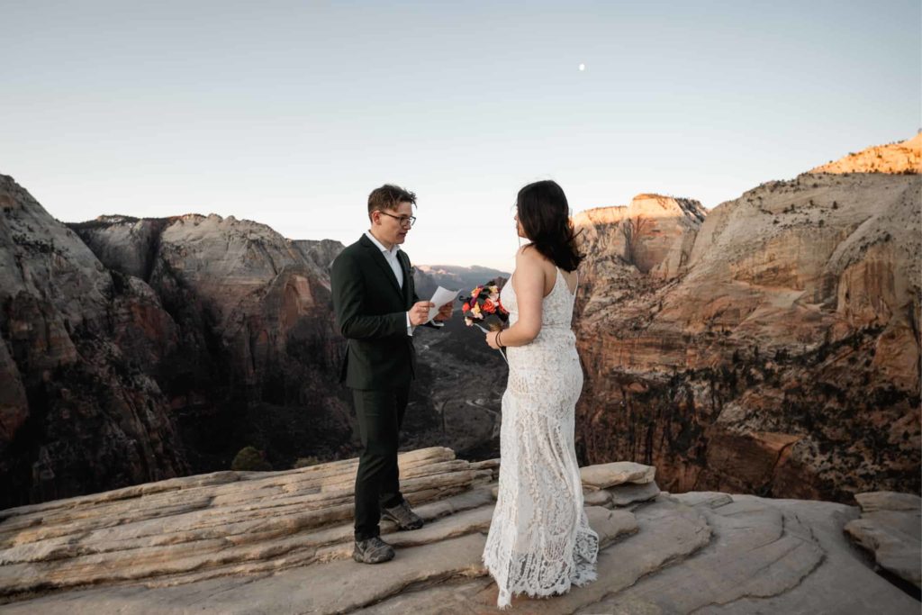 Beautiful wedding photo of Bride and Groom saying their vows along the mountain ranges