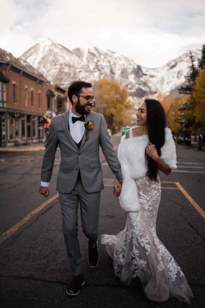 telluride destination wedding of bride and groom running down the town