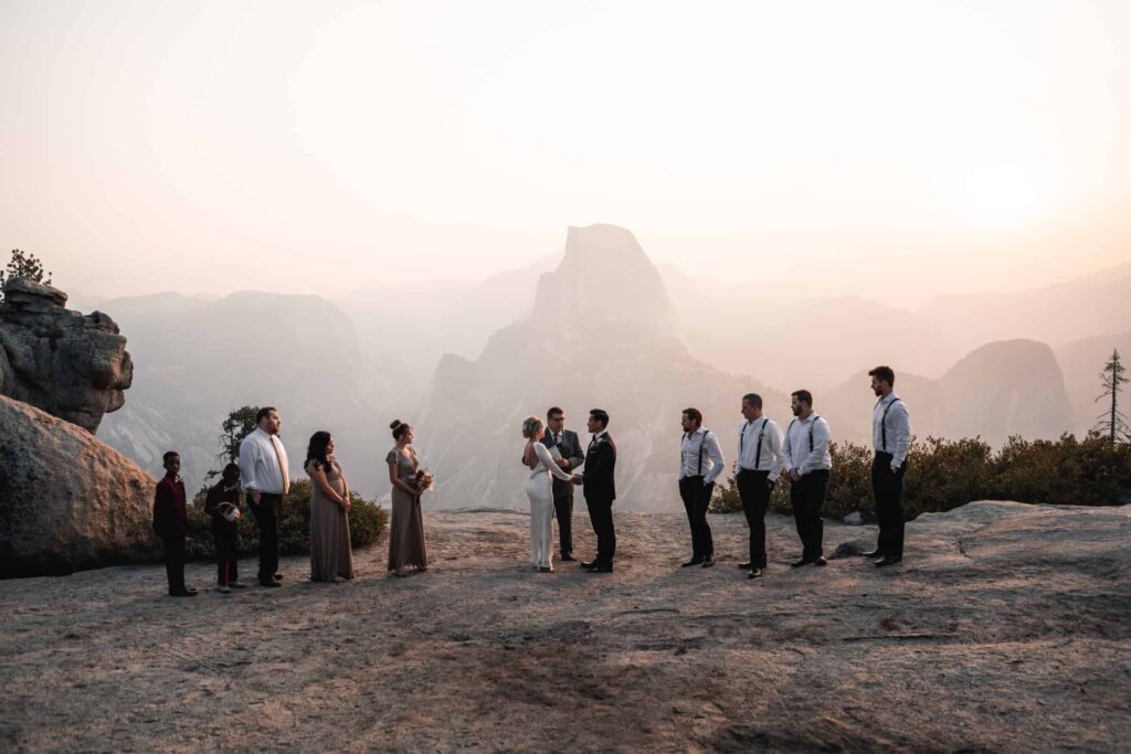 couple standing in front of glacier point in yosemite for their destination wedding ceremony